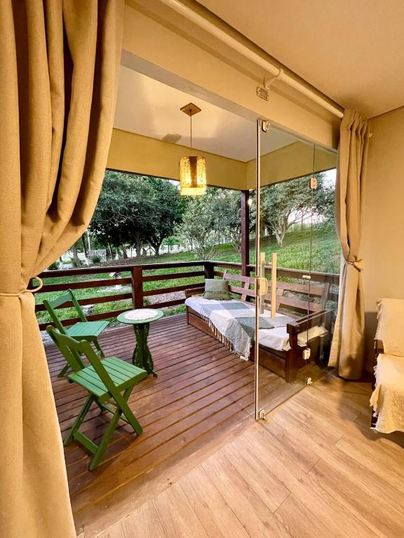 a room with a balcony with green chairs and a table at Rancho Dreamland in Gaspar
