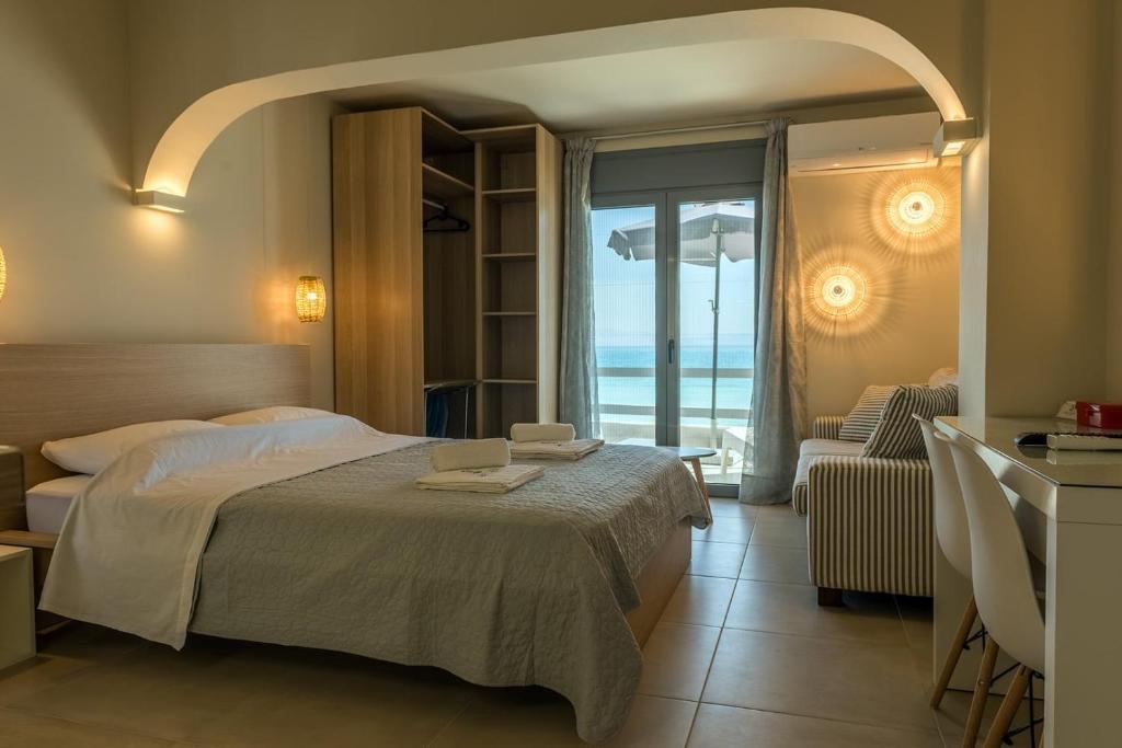 a bedroom with a bed and a view of the ocean at Sea Salt Studios in Nerántza