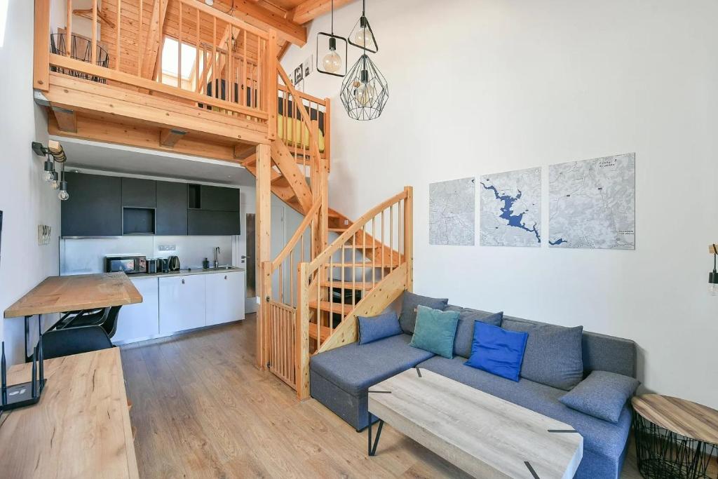 a living room with a couch and a staircase at Relax in Korzo Lipno in Lipno nad Vltavou