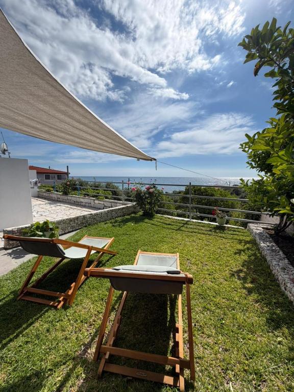 a table and a chair on the grass with a laptop at Olive tree villa in Ligia