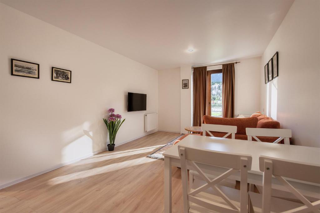 a white living room with a couch and a table at Sella Mestia in Mestia