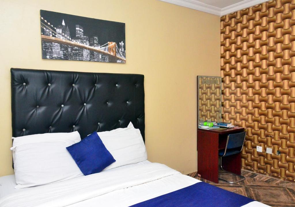 a bedroom with a bed with a black headboard at P Meridian Hotels in Awoyaya