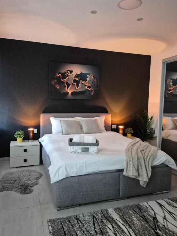 a bedroom with a large bed with a black wall at STD AFRODITA Apartment & Garden in Vrdnik