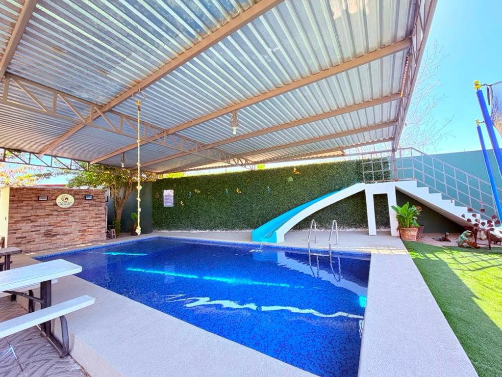 a swimming pool under a metal roof with a swimming poolvisor at Casa Completa in Rancho San Pedro