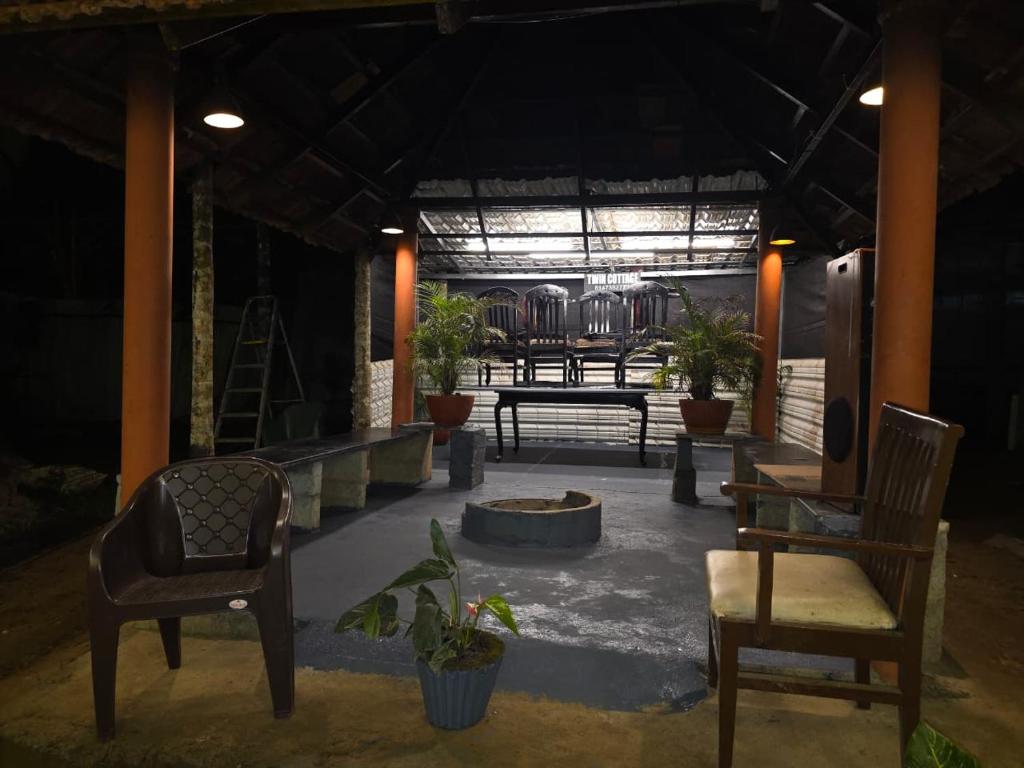 a patio with chairs and a table and benches at Twin Retreat in Madikeri