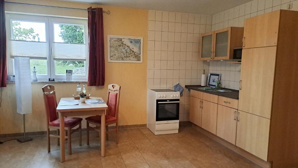 a small kitchen with a table and a table and chairs at Ferienwohnung Riemer in Garz