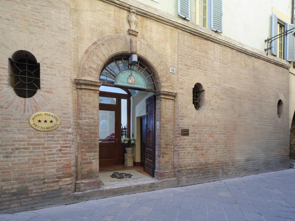 an entrance to a brick building with an open door at Palazzo Brunamonti Boutique Hotel in Bevagna