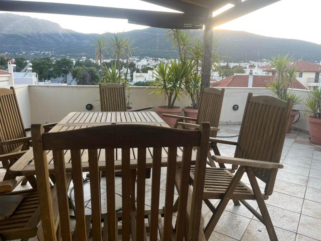 a wooden table and chairs sitting on a balcony at K-Loft Urban Athens in Pallini