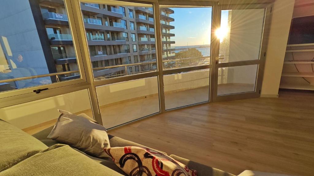 a living room with a couch and a large window at Viento Sur Anfitrionas "Centro" in Puerto Madryn