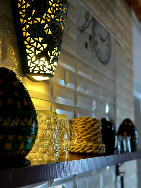 a shelf with glasses and a clock on a wall at Moroohouse in Dahab