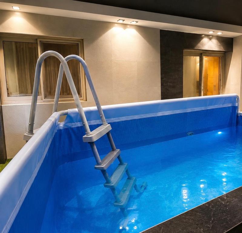a blue swimming pool with a ladder in it at Leila Home Garden - Maamourah Beach in Alexandria