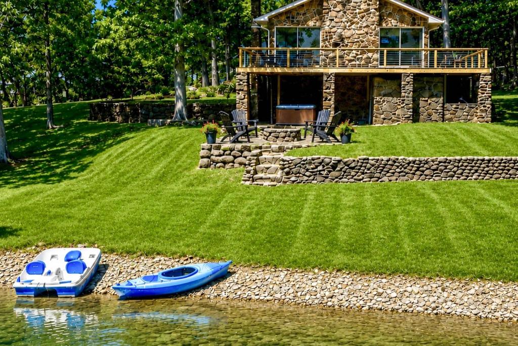 two boats sitting on the water in front of a house at Pub, Hot Tub, Game Room, Monkey Island Waterfront in Afton