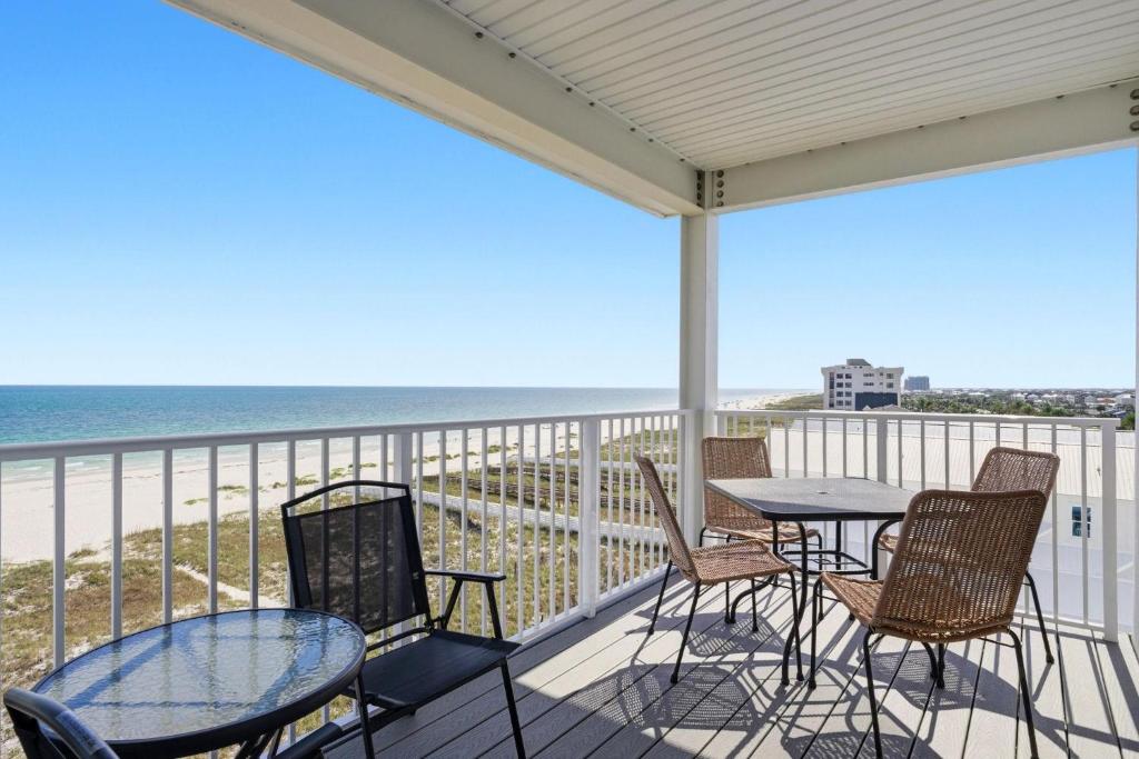 a balcony with tables and chairs and the ocean at Riviera Dunes 503 in Perdido Key