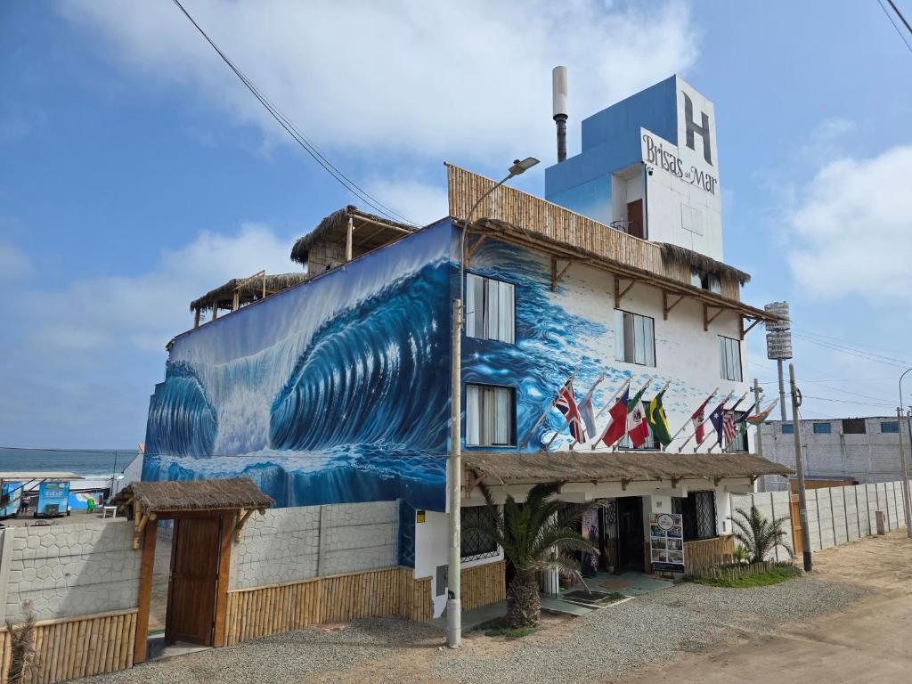 a building with a painting of the ocean on it at Hostal Brisas del Mar in Punta Negra