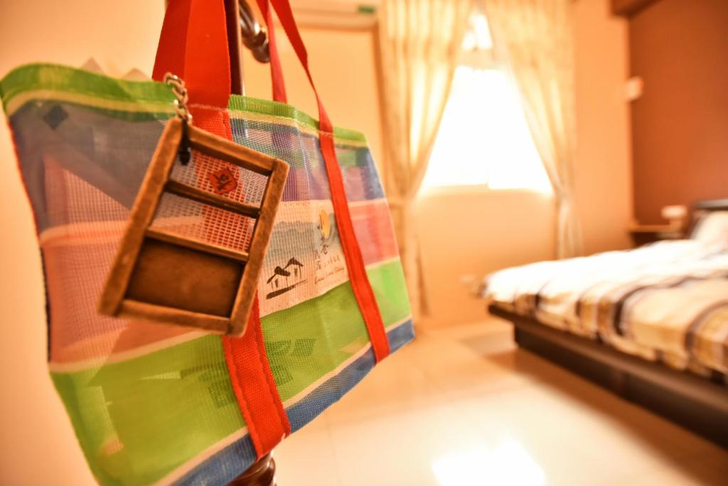 a room with a bed and a bag hanging from a wall at Lane Homestay in Dayin