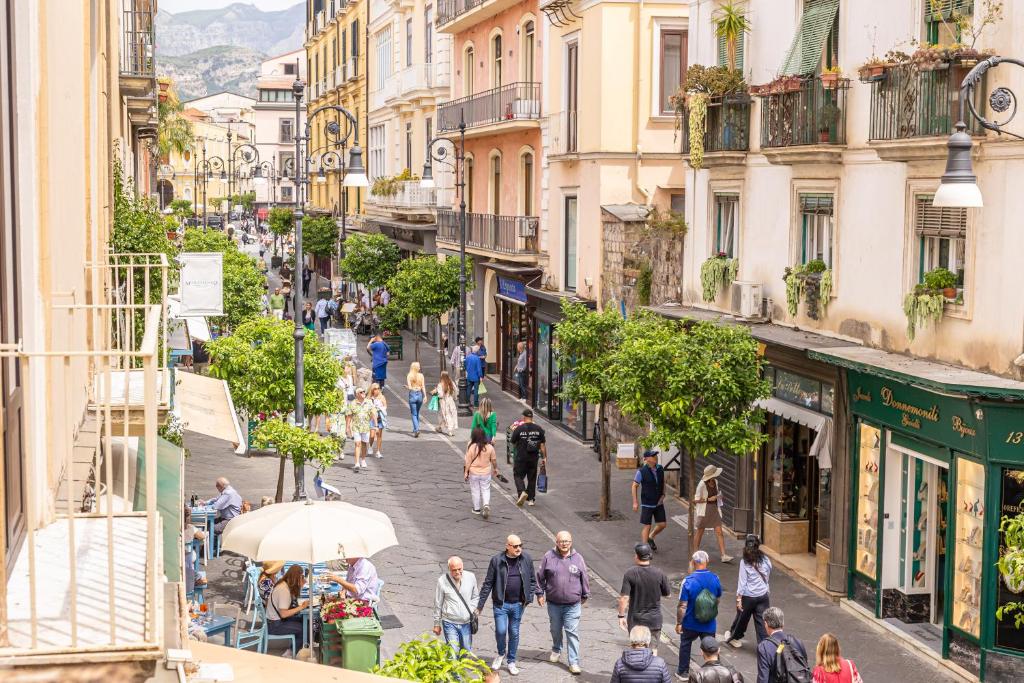 a crowd of people walking down a street in a city at Maison Il Corso in Sorrento