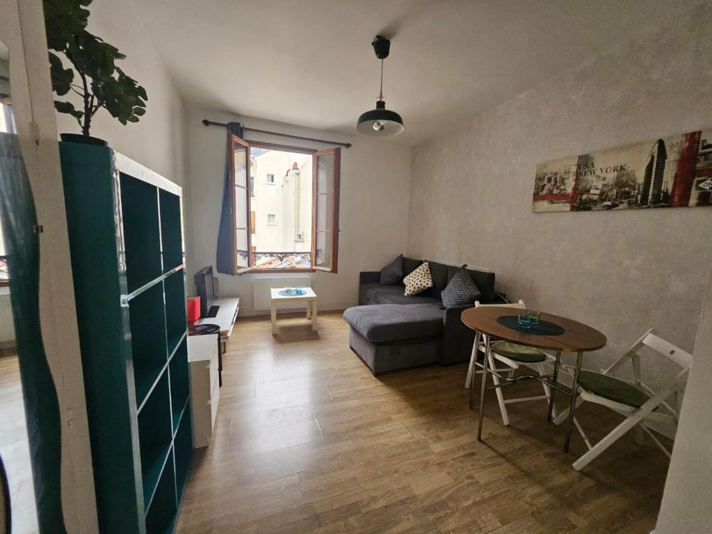 a living room with a couch and a table at Hébergement SARAH in Paris