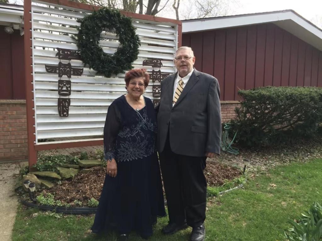 a man and a woman standing in front of a house at Charming Bedroom with Private Bathroom in Ann Arbor