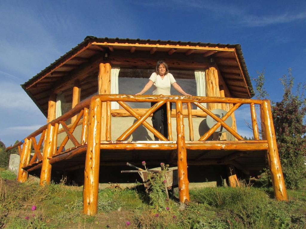 a woman standing in the window of a tree house at Cabañas El Muelle in Cholila