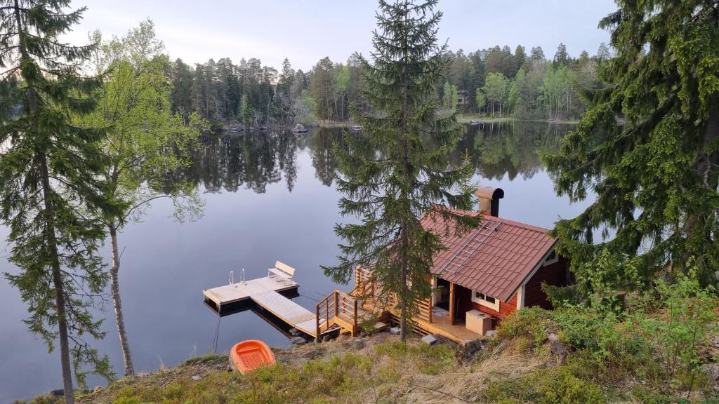 a cabin on the shore of a lake with a dock at Villa Karhurinne in Lempäälä
