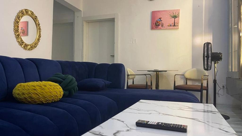 a blue couch in a living room with a table at Otunba's Crib in Gbogije