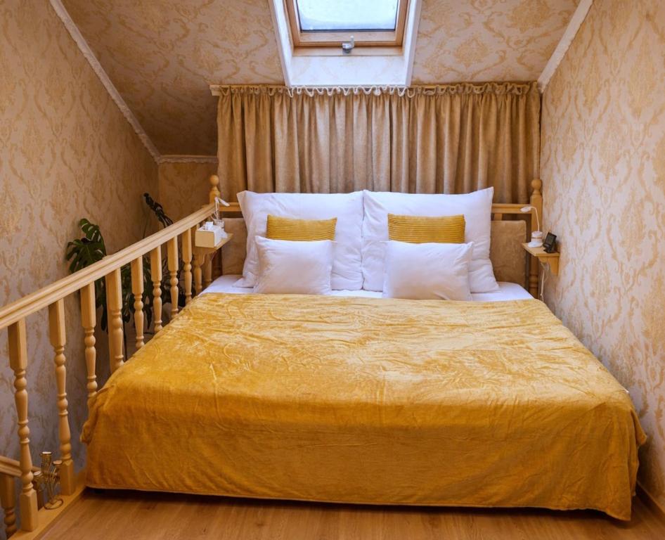 a bedroom with a bed with yellow sheets and pillows at Jázmin Apartman in Debrecen