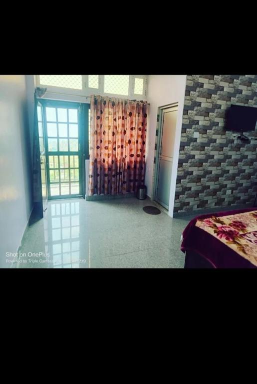 a bedroom with a bed and a door with a window at Shree mangalam homestay in Bhīm Tāl