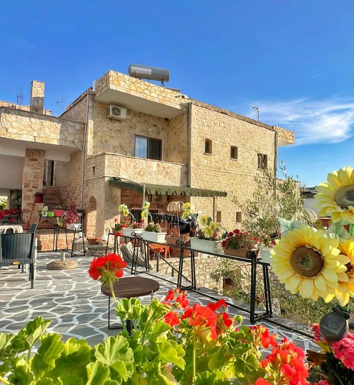 a building with tables and flowers in front of it at Handmade Stone Villa in Ksamil