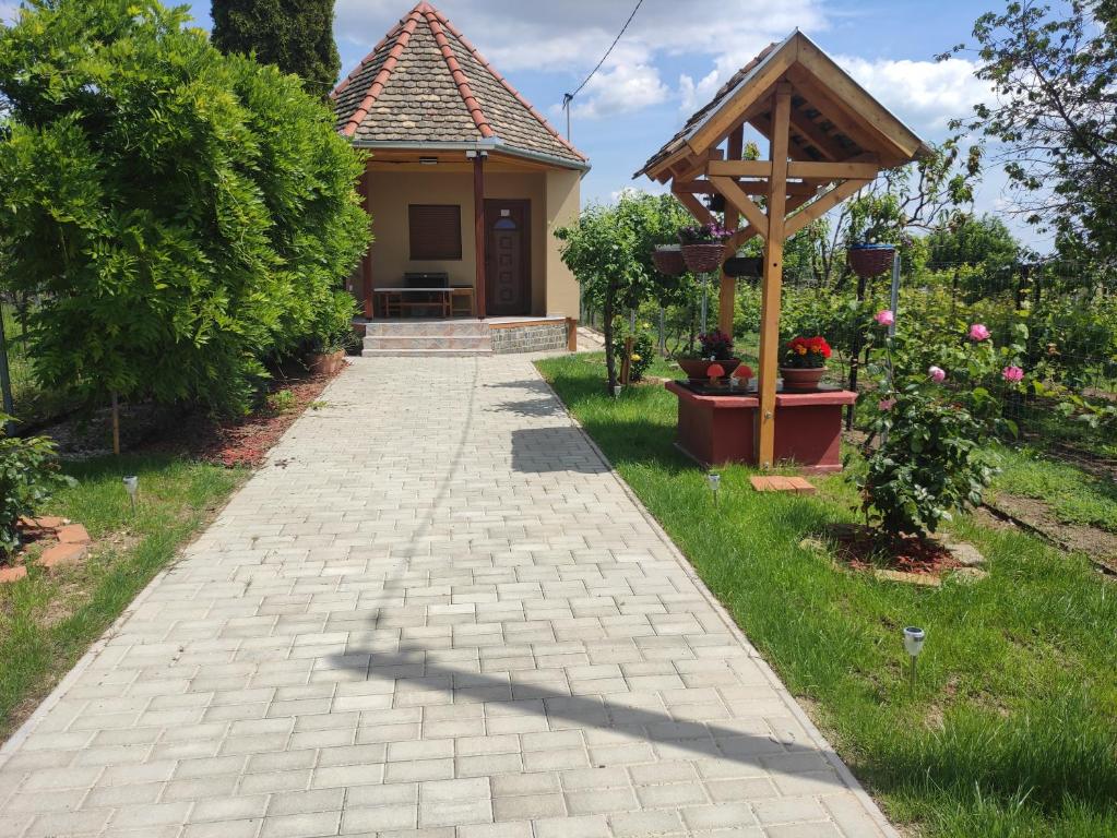 a brick walkway leading to a house with a gazebo at Barna kuckó in Mohács