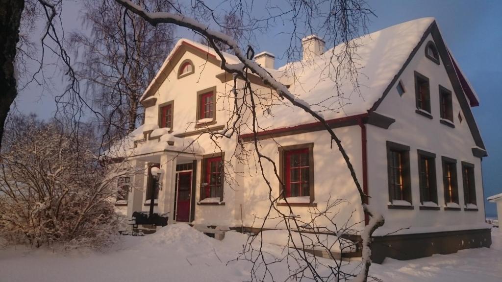 a white house with snow on the roof at Virulase Holiday Home in Toila