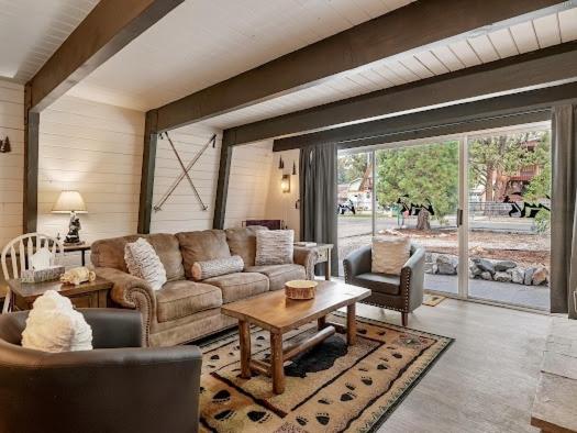 a living room with a couch and a table at Cozy Pet Friendly Big Bear Cabin in Big Bear City