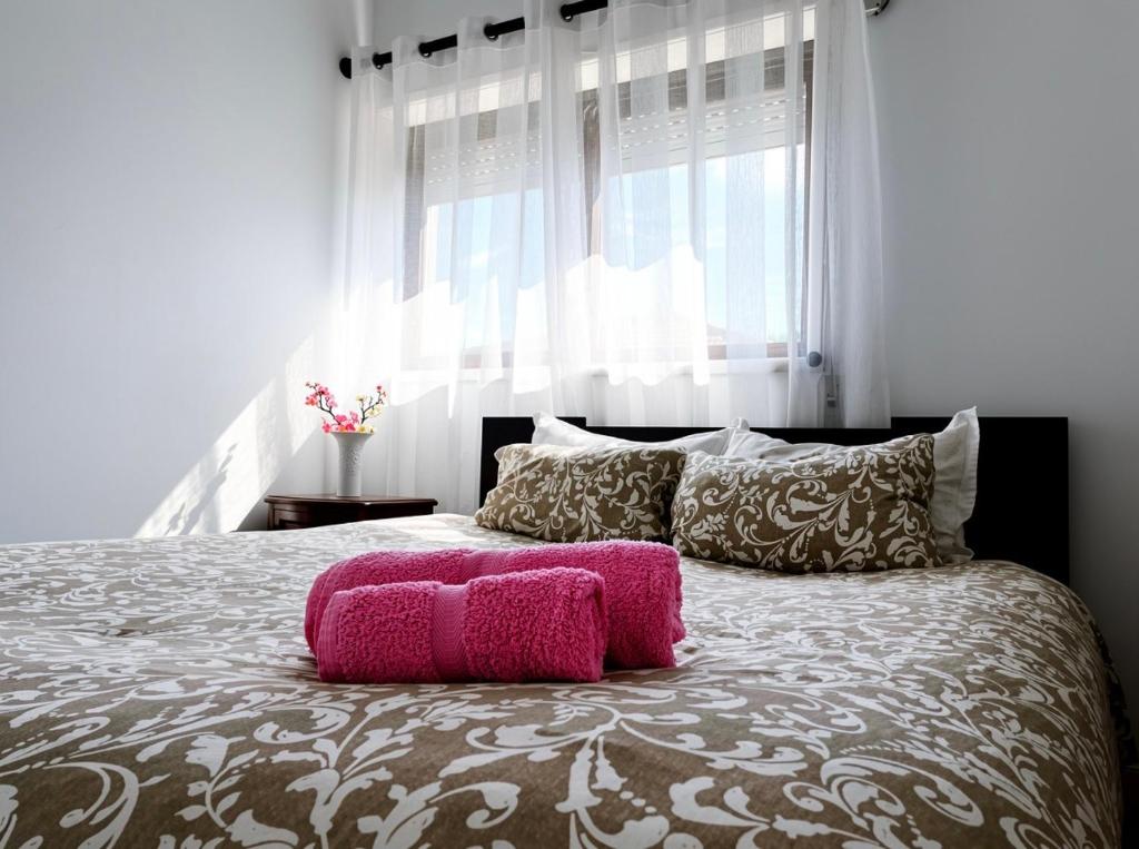 a bedroom with a large bed with a pink pillow on it at Casa de férias in Monte