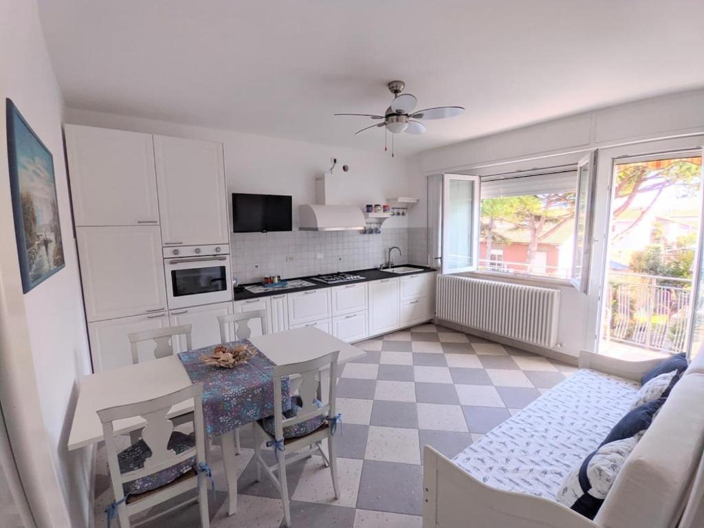 a kitchen with white cabinets and a table and a window at Maréthias in Punta Marina