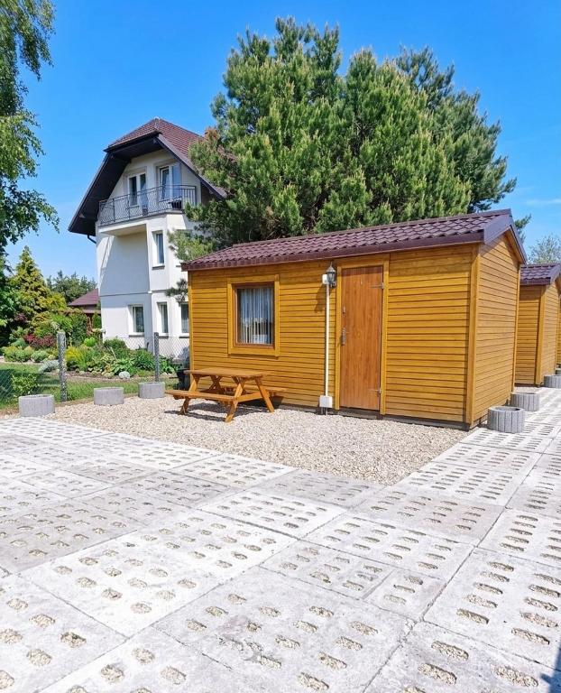 a wooden cabin with a bench in front of a building at Miodowe Domki in Władysławowo