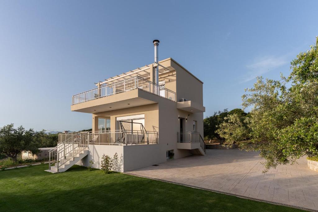 a house with a balcony and a yard at Casa Elaia in Pylos