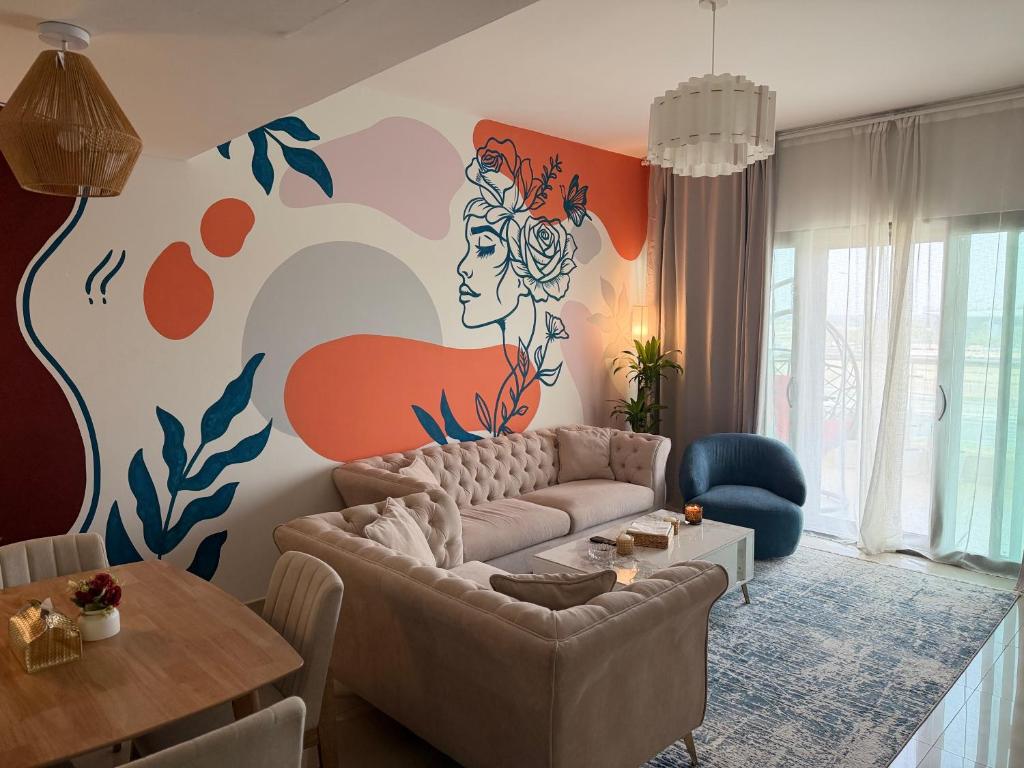 a living room with a couch and a painting on the wall at Al Raha Beach modern 1 bedroom near AD airport in Abu Dhabi