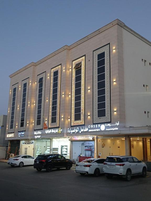 a building with cars parked in front of it at شقق أونيسن للشقق المخدومة Onsen Serviced Apartments in Buraydah