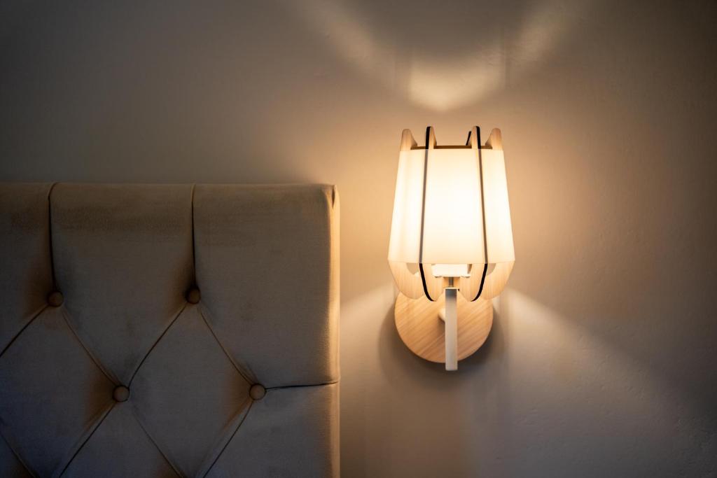 a light on a wall next to two chairs at Red Dragon Exclusive accommodation in Dassia