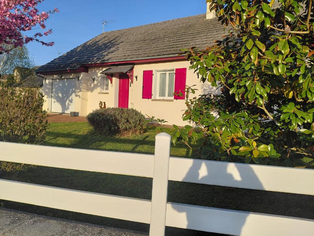a white fence in front of a house with red shutters at Spacieuse maison "Des 3 filles" pour 6 personnes in Ally