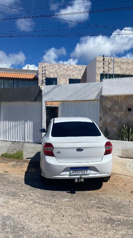 a white car parked in front of a building at Casa Arembepe 2 in Camaçari