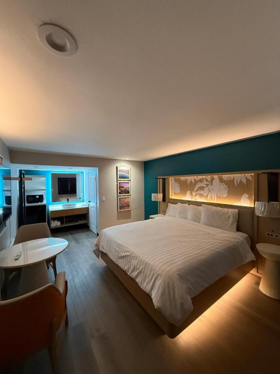 a bedroom with a large bed and a blue wall at Harbor Bay Inn in Costa Mesa
