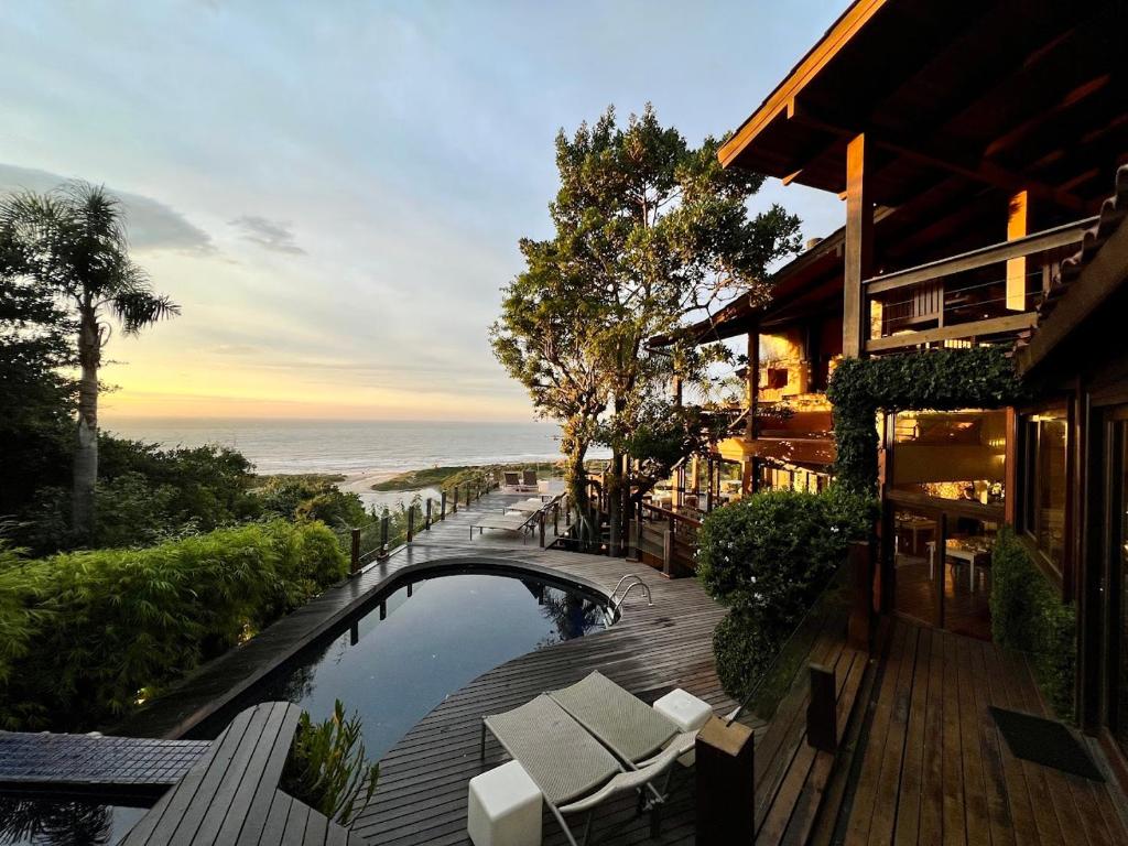 a resort with a swimming pool and a deck with chairs at Pousada Quinta do Bucanero in Imbituba
