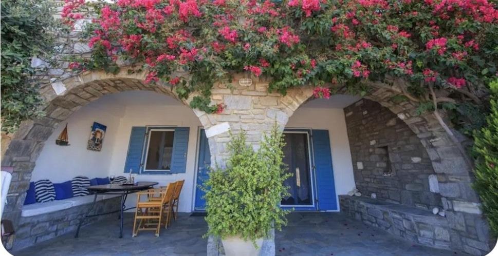 a building with an arch with pink flowers on it at Anemos in Drios