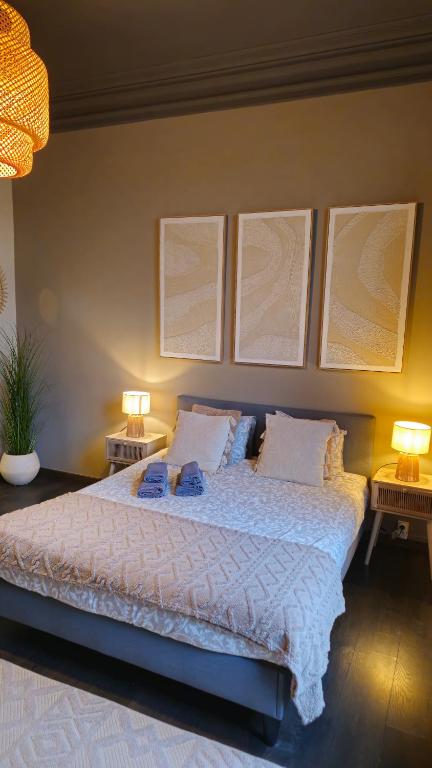 a bedroom with a bed with three pictures on the wall at LA SUITE 159 in Namur