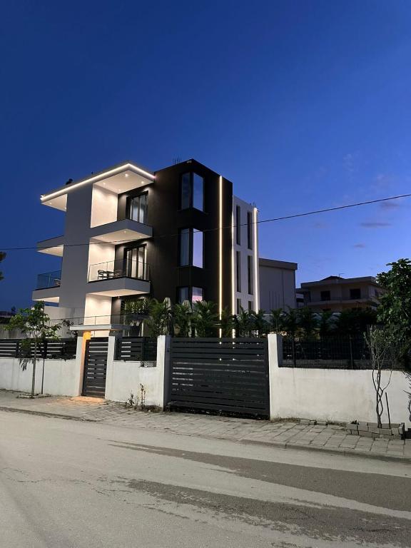a building on the side of a street with a fence at Hotel Aluor in Vlorë