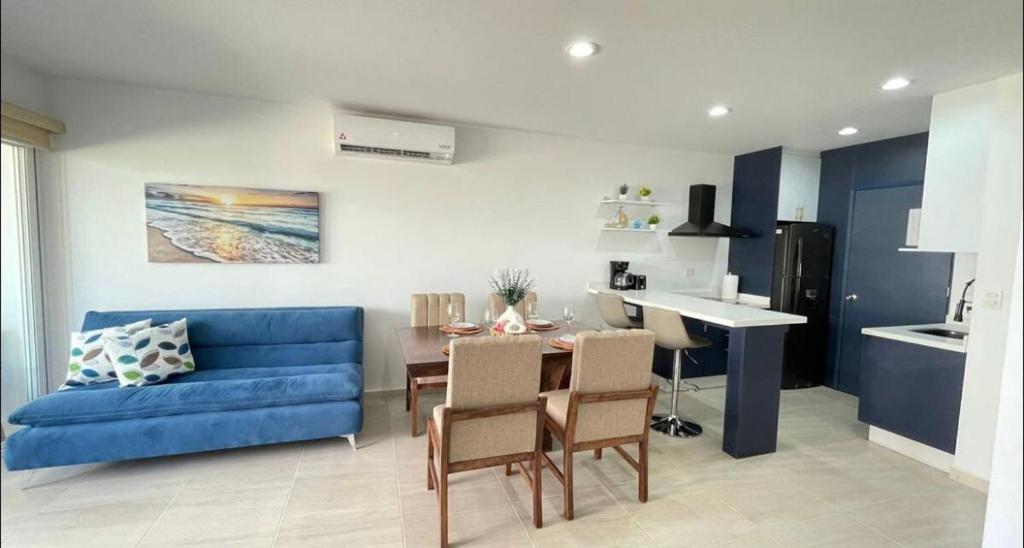 a living room with a blue couch and a table at Almarena Mazatlan Departamento Nautico in Mazatlán