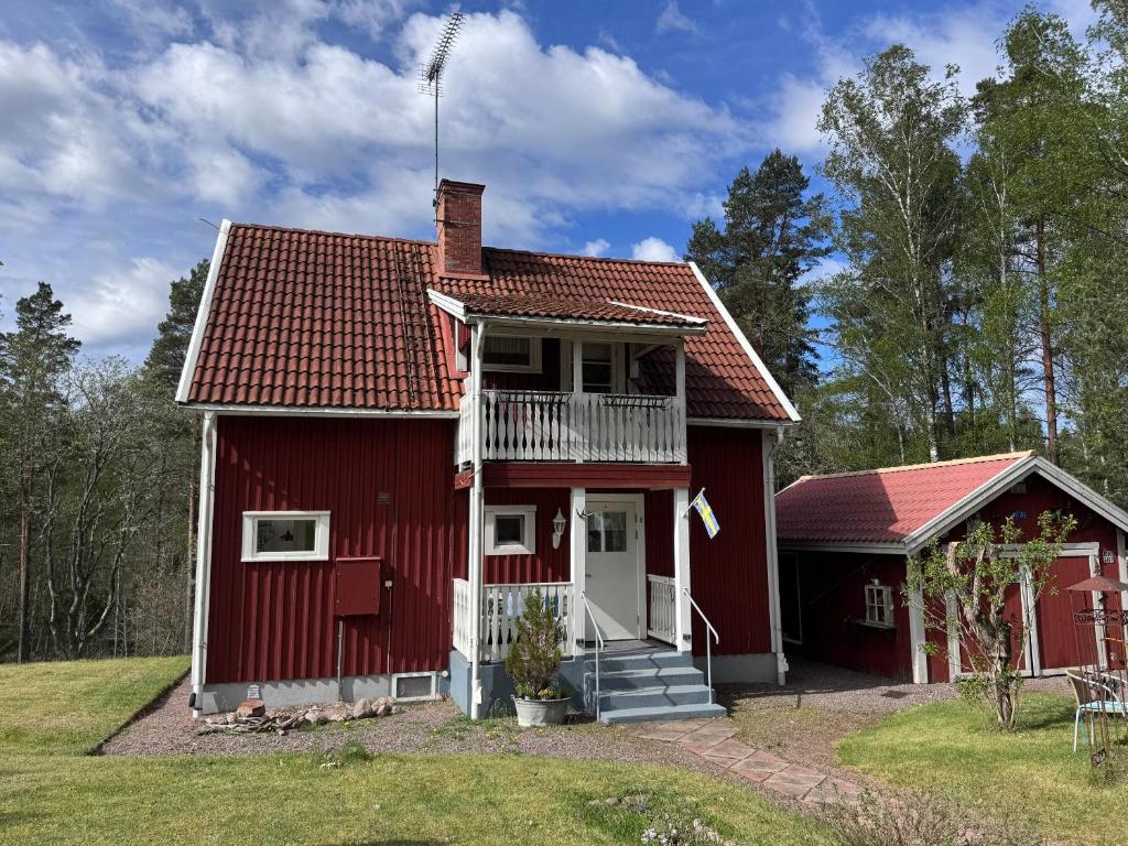 a red house with a red roof at Sommerhaus Luisa in Vimmerby