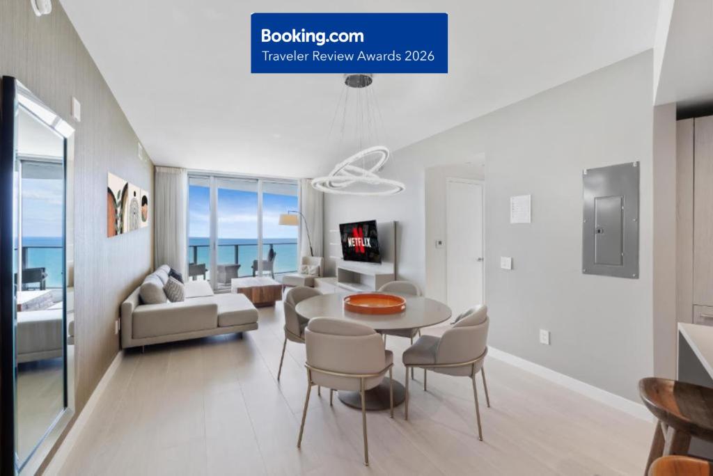 a white living room with a table and chairs at EXCLUSIVE RESORT - OCEANFRONT 2BD 2BA CONDO, HiGH FLOOR, ROOFTOP POOL AND HOT TUB, STEPS TO BEACH in Hollywood