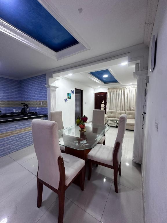a dining room with a glass table and white chairs at Lohana's House Beach in Cartagena de Indias