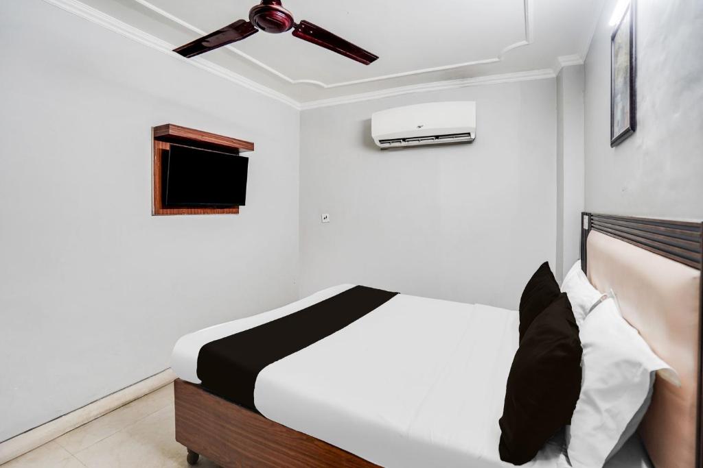 a bedroom with a bed and a ceiling fan at Hotel O by OYO Exotica Palace in New Delhi